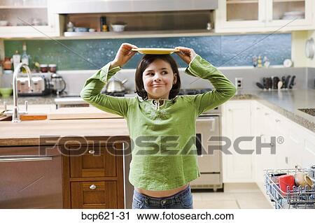 Playful girl balancing plate on her head View Large Photo Image Stock Image - Playful girl balancing plate on her head. Fotosearch