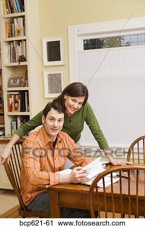 Portrait of couple doing paperwork at home View Large Photo Image Stock Image - Portrait of couple doing paperwork at home. Fotosearch