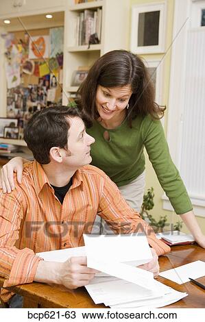 Portrait of couple doing paperwork at home View Large Photo Image Stock Image - Portrait of couple doing paperwork at home. Fotosearch