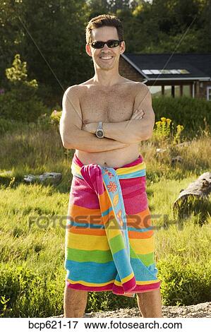 Stock Photo - Portrait of smiling man in beach towel. Fotosearch