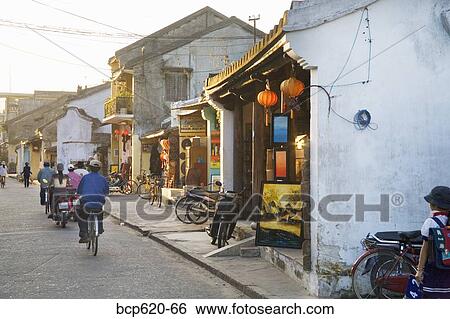 Stock Photograph - Street with shops and people in Vietnamese town. Fotosearch