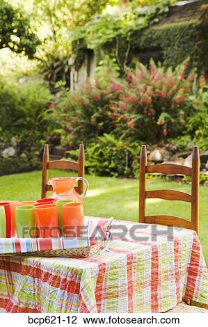 Table and chairs in garden with beverages View Large Photo Image Stock Image - Table and chairs in garden with beverages. Fotosearch