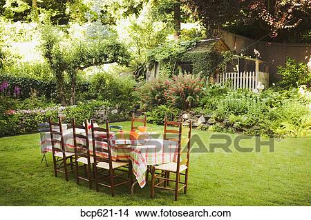 Picture - Table and chairs on lawn in garden. Fotosearch