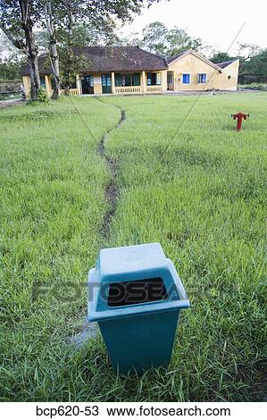 Trash can in field with path to building View Large Photo Image Stock Image - Trash can in field with path to building. Fotosearch
