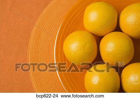 Whole oranges on orange plate View Large Photo Image Picture - Whole oranges on orange plate. Fotosearch