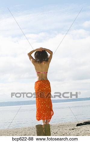 Stock Photo - Woman in swimming suit on beach. Fotosearch
