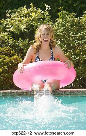 Woman splashing her feet in pool View Large Photo Image Stock Image - Woman splashing her feet in pool. Fotosearch