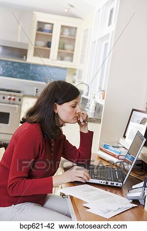 Woman using laptop computer in kitchen View Large Photo Image Stock Image - Woman using laptop computer in kitchen. Fotosearch