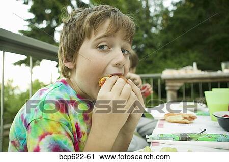 Young boy eating lunch outside View Large Photo Image Stock Image - Young boy eating lunch outside. Fotosearch