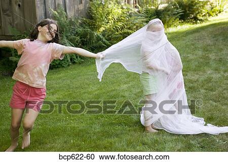 Young girl wrapping friends in fabric View Large Photo Image Stock Image - Young girl wrapping friends in fabric. Fotosearch