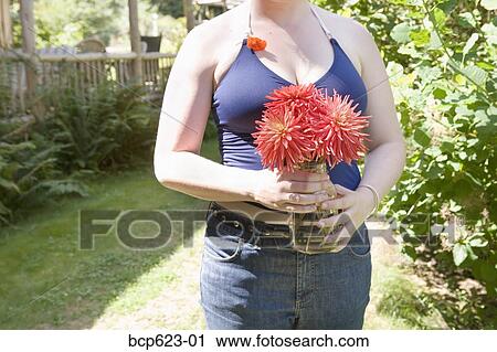 Young woman holding jar of cut flowers View Large Photo Image Stock Image - Young woman holding jar of cut flowers . Fotosearch