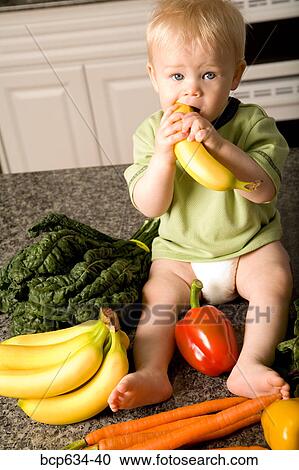 Stock Image - baby, banana, bell pepper, biting, boy, carrot. Fotosearch