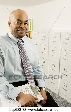 balding, file cabinet, clipboard, businessman, african ethnicity View Large Photo Image Stock Image - balding, file cabinet, clipboard, businessman, african ethnicity. Fotosearch