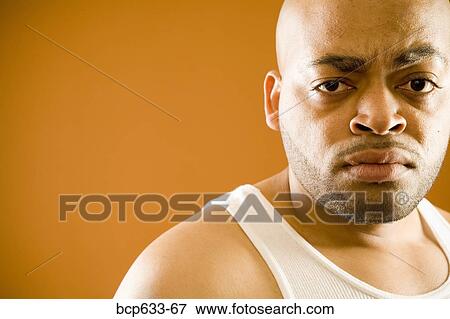Stock Photo - balding, frowning, fortysomething, close up, african ethnicity. Fotosearch