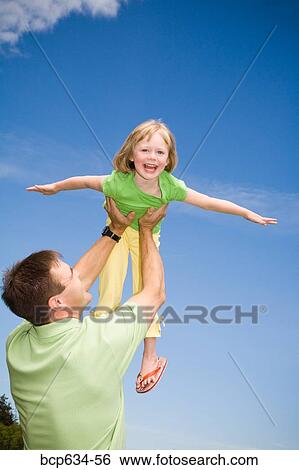 Stock Photograph - blue sky, daughter, childhood, caucasian, afternoon. Fotosearch