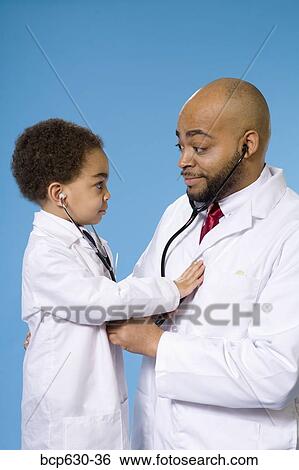 Stock Photograph - boy, doctor, childhood, caring, african ethnicity. Fotosearch
