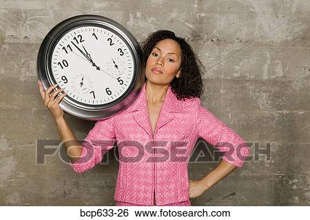 Stock Photograph - businesswoman, clock, african ethnicity. Fotosearch