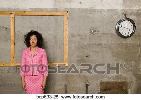 Stock Photography - businesswoman, inside, clock, african ethnicity. Fotosearch