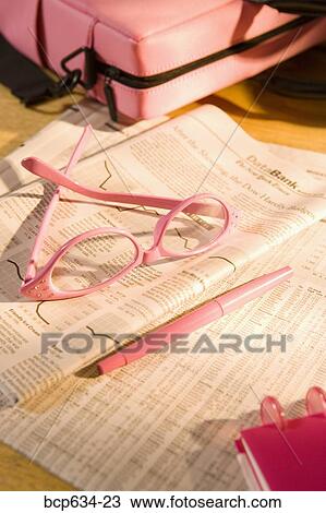 Stock Image - case, eyeglasses, finance, high angle, inside, newspaper. Fotosearch