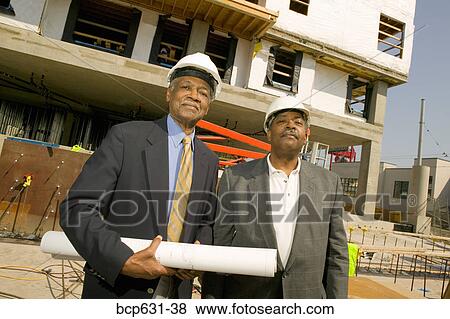 Stock Photo - co-worker, afternoon, businessman, business, blueprint, african ethnicity. Fotosearch