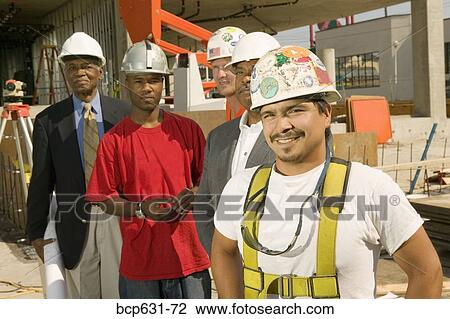 Stock Image - construction, afternoon, co-worker, caucasian, blueprint, african ethnicity. Fotosearch