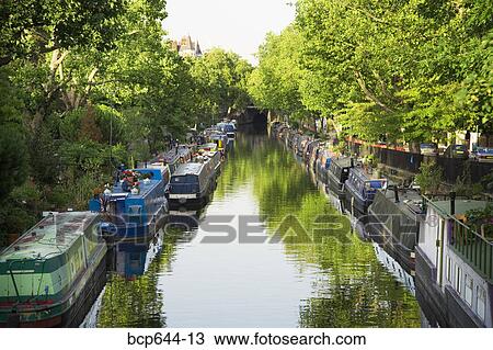 Stock Image - Boats lining riverbanks, London, United Kingdom. Fotosearch