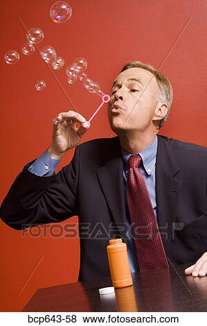 Stock Photo - Businessman blowing bubbles. Fotosearch