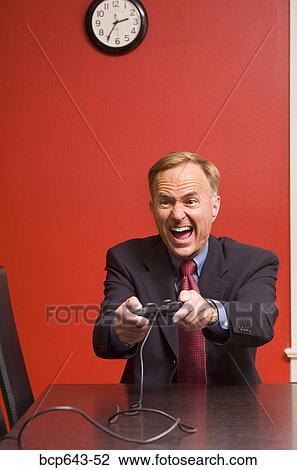Businessman playing video games View Large Photo Image Stock Image - Businessman playing video games. Fotosearch