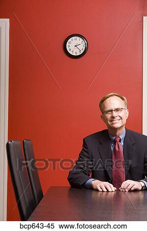 Businessman sitting alone at conference table View Large Photo Image Stock Photography - Businessman sitting alone at conference table. Fotosearch