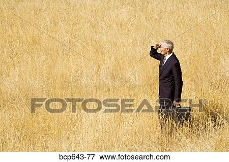 Businessman standing in field View Large Photo Image Stock Photo - Businessman standing in field. Fotosearch
