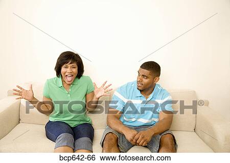 Stock Photograph - Couple arguing on a couch. Fotosearch