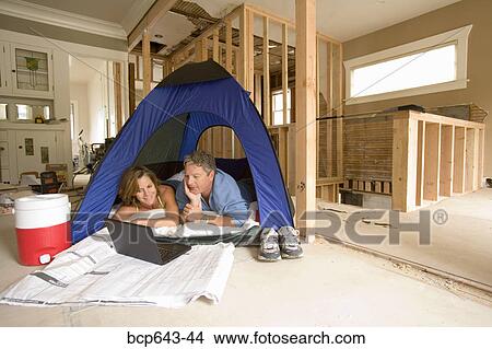 Couple camping in their unfinished living room View Large Photo Image Picture - Couple camping in their unfinished living room. Fotosearch