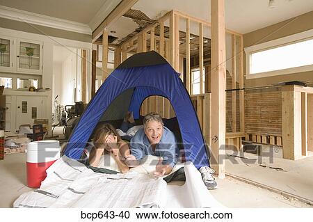 Couple camping in their unfinished living room View Large Photo Image Stock Image - Couple camping in their unfinished living room. Fotosearch
