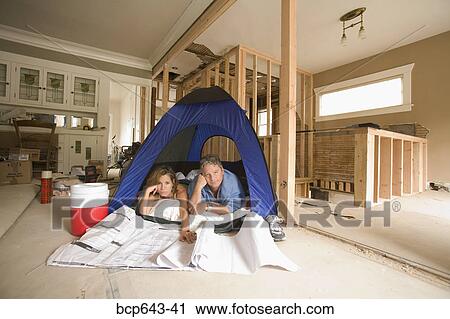 Couple camping in their unfinished living room View Large Photo Image Stock Image - Couple camping in their unfinished living room. Fotosearch