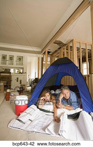 Couple camping in their unfinished living room View Large Photo Image Stock Image - Couple camping in their unfinished living room. Fotosearch