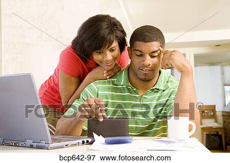 Couple doing their finances together View Large Photo Image Stock Photo - Couple doing their finances together. Fotosearch