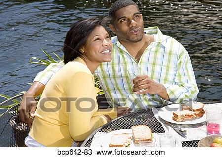 Couple eating by lake outdoors View Large Photo Image Stock Image - Couple eating by lake outdoors. Fotosearch