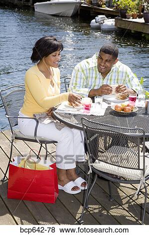 Couple eating on deck by lake View Large Photo Image Stock Photo - Couple eating on deck by lake. Fotosearch