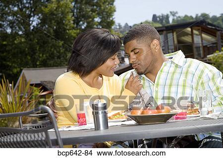 Picture - Couple eating outdoors. Fotosearch