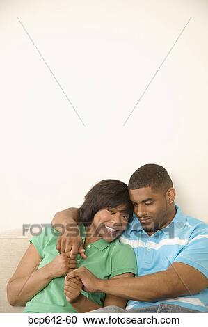 Couple hugging on a couch View Large Photo Image Stock Image - Couple hugging on a couch. Fotosearch
