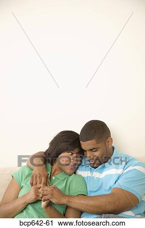Couple hugging on a couch View Large Photo Image Stock Image - Couple hugging on a couch. Fotosearch