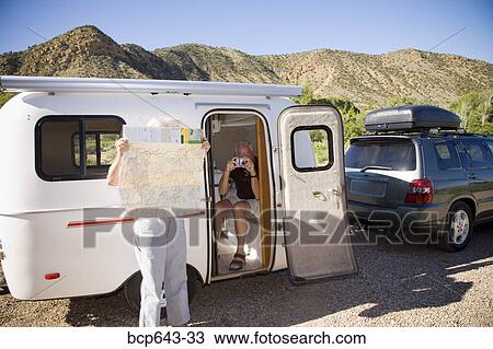 Couple stopping to check directions on a road trip View Large Photo Image Stock Image - Couple stopping to check directions on a road trip. Fotosearch