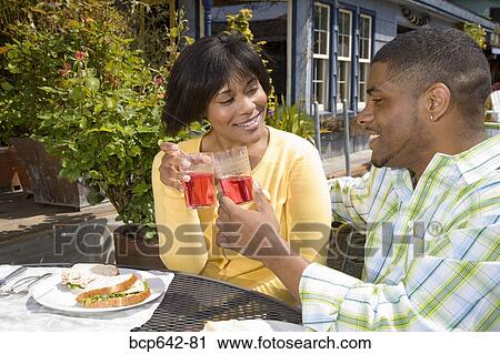 Couple toasting each other outdoors View Large Photo Image Stock Image - Couple toasting each other outdoors. Fotosearch