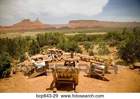 Stock Photo - Empty chairs around table in desert. Fotosearch