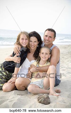Family hugging on the beach View Large Photo Image Stock Photo - Family hugging on the beach. Fotosearch
