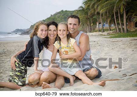 Family hugging on the beach View Large Photo Image Stock Photo - Family hugging on the beach. Fotosearch