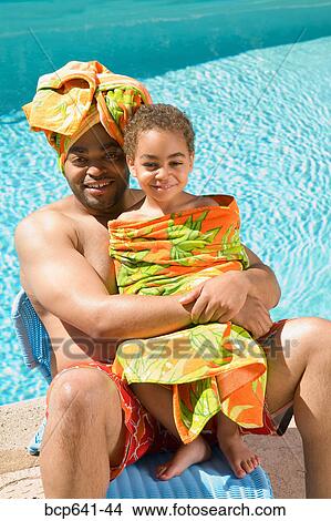 Picture - Father and son drying off by pool. Fotosearch