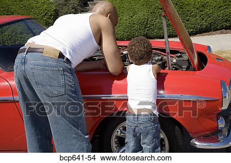 Father and son examining under car hood View Large Photo Image Picture - Father and son examining under car hood. Fotosearch