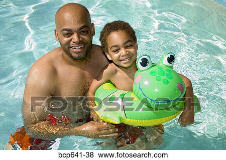 Father and son playing in pool View Large Photo Image Stock Photo - Father and son playing in pool. Fotosearch