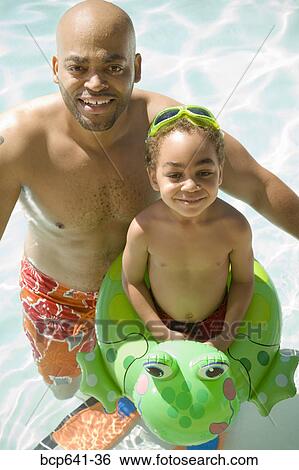 Father and son playing in pool View Large Photo Image Stock Photograph - Father and son playing in pool. Fotosearch